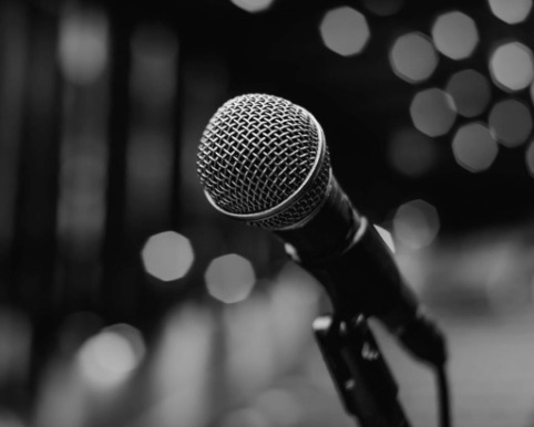 Stage microphone on its stand against soft out-of-focus lights